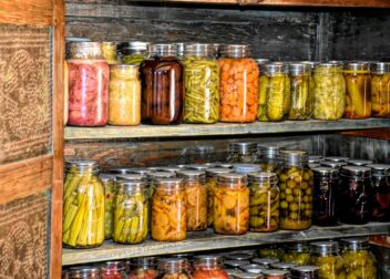 a wooden shelf filled with lots of jars of food