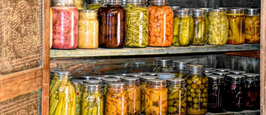 a wooden shelf filled with lots of jars of food
