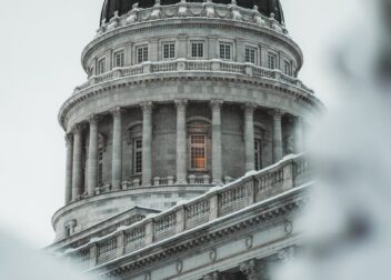 Close-up of a snow-covered Capitol building dome captured in a winter landscape.