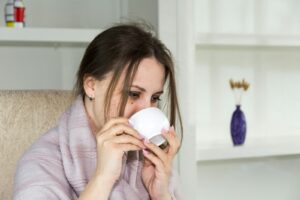 a woman sitting in a chair drinking from a cup